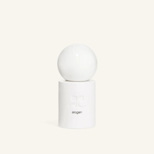 Close up of the white sphere atop the Slogan bottle with embossed letters on the cylinder