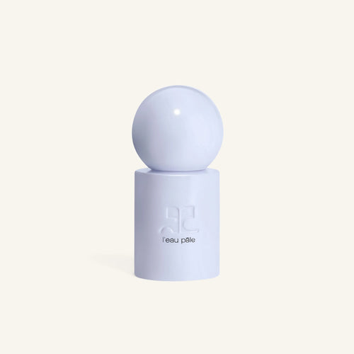 Partial view of the pale blue sphere cap of Courrèges L'eau Pâle bottle against a cream background.