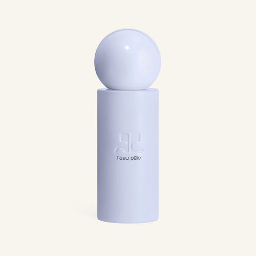 Courrèges L'eau Pâle perfume bottle with pale blue spherical cap on a white pedestal.